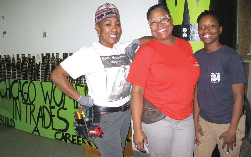 Three african-american women wearing construction belts and workers clothes