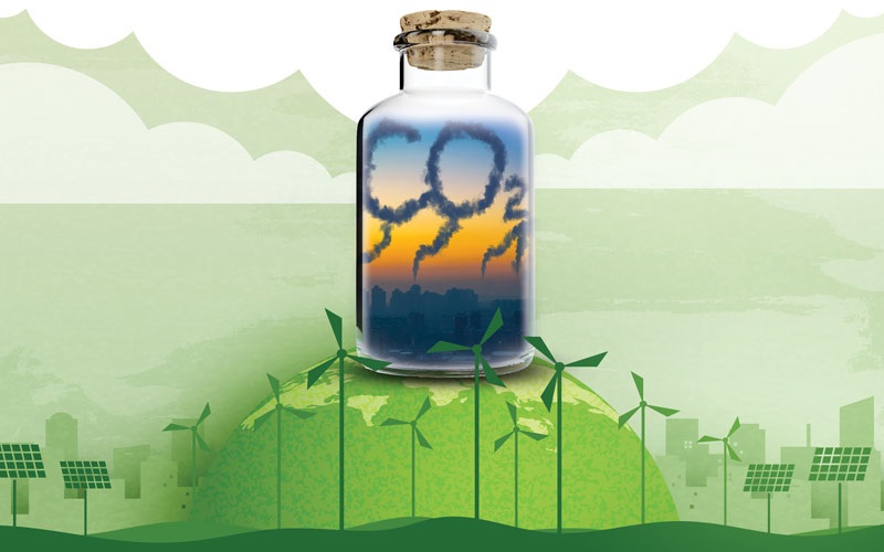 A bottle filled with the word "CO2" sits on top of a hill, surrounded by solar panels and wind turbines. STOCK.ADOBE.COM / AAPSKY / KEGFYLD / SHUTTERSTOCK / MAN AS THEP
