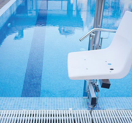 Pool lift chair installed at the edge of a swimming pool, illustrating equipment subject to new NEC equipotential bonding requirements and ADA requirements for accessibility and electrical safety.