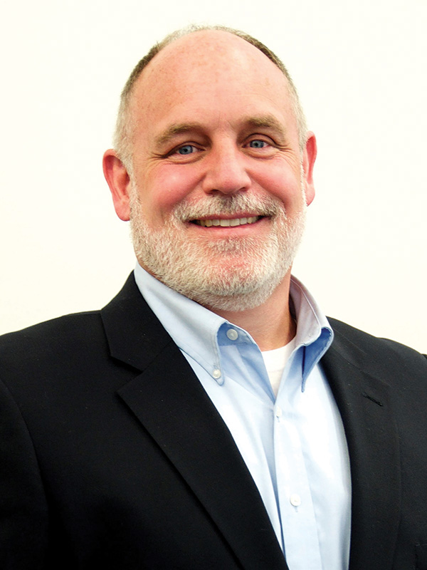 Chuck Fairchild headshot. A white man with blue eyes and graying hair smiles at the camera.