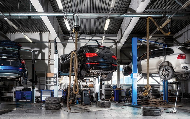 Car repair on a lift for the repair of the chassis, automatic transmission and engine in the auto repair shop or garage. Car workshop concept