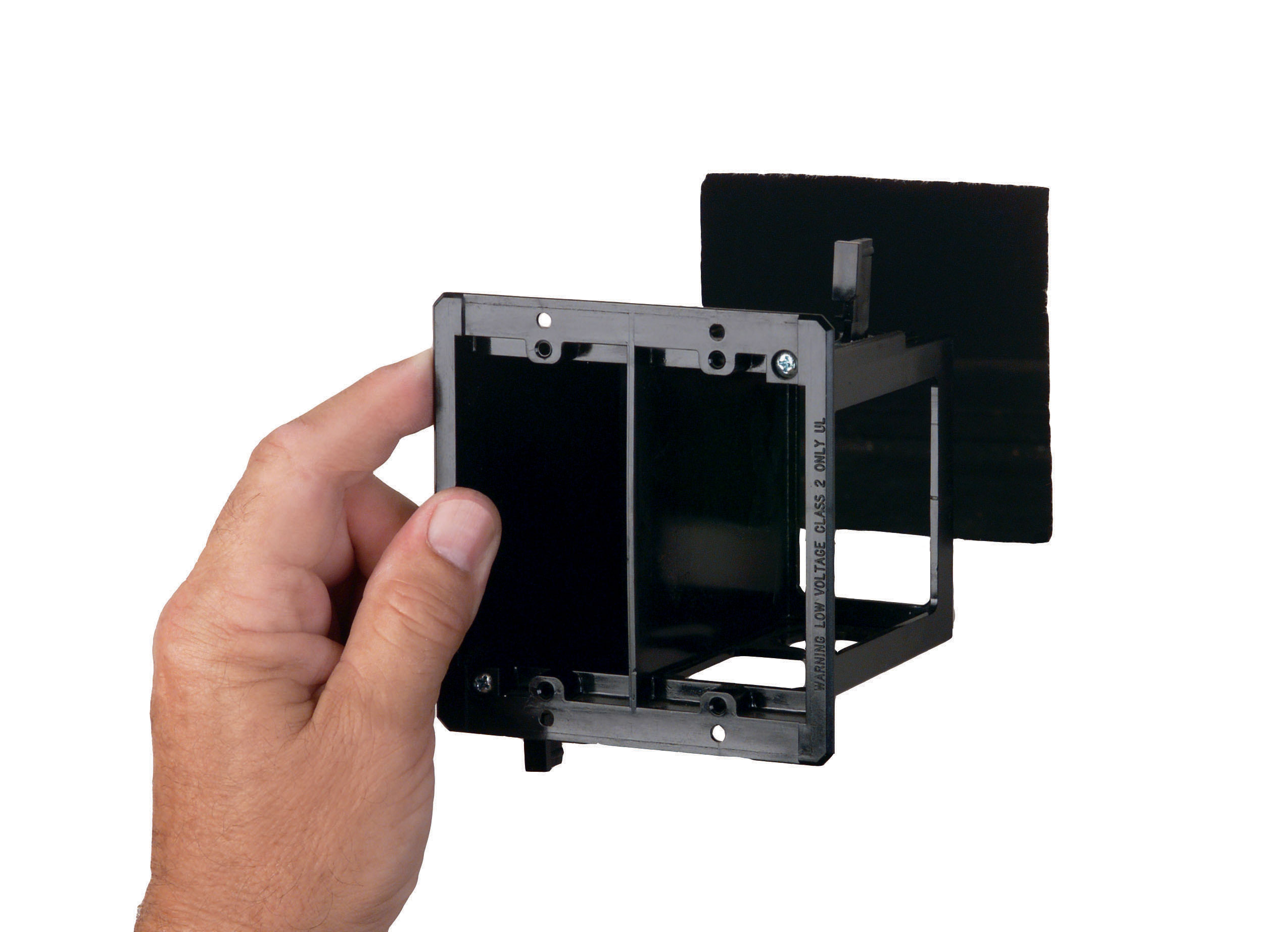 Hand holding a black wall box. Image by Arlington Industries.